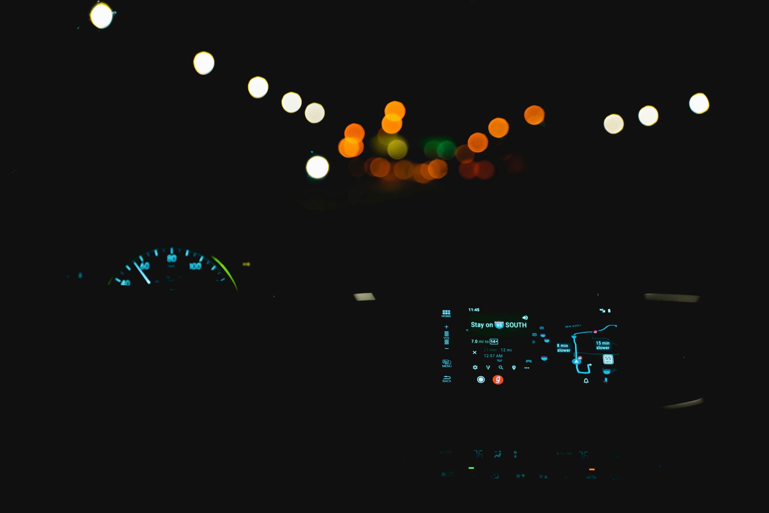 A car dashboard glowing softly, suggesting motion and quiet tension