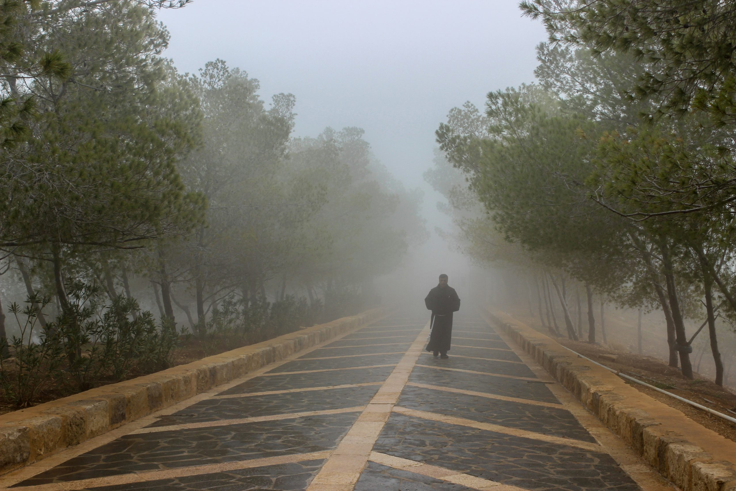 Person standing at a foggy crossroads, representing project uncertainty and drift.