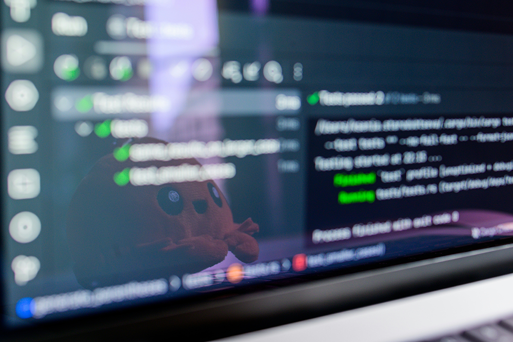 A blurred laptop screen with workflow notes and artificial intelligence prompts, representing rushed digital production